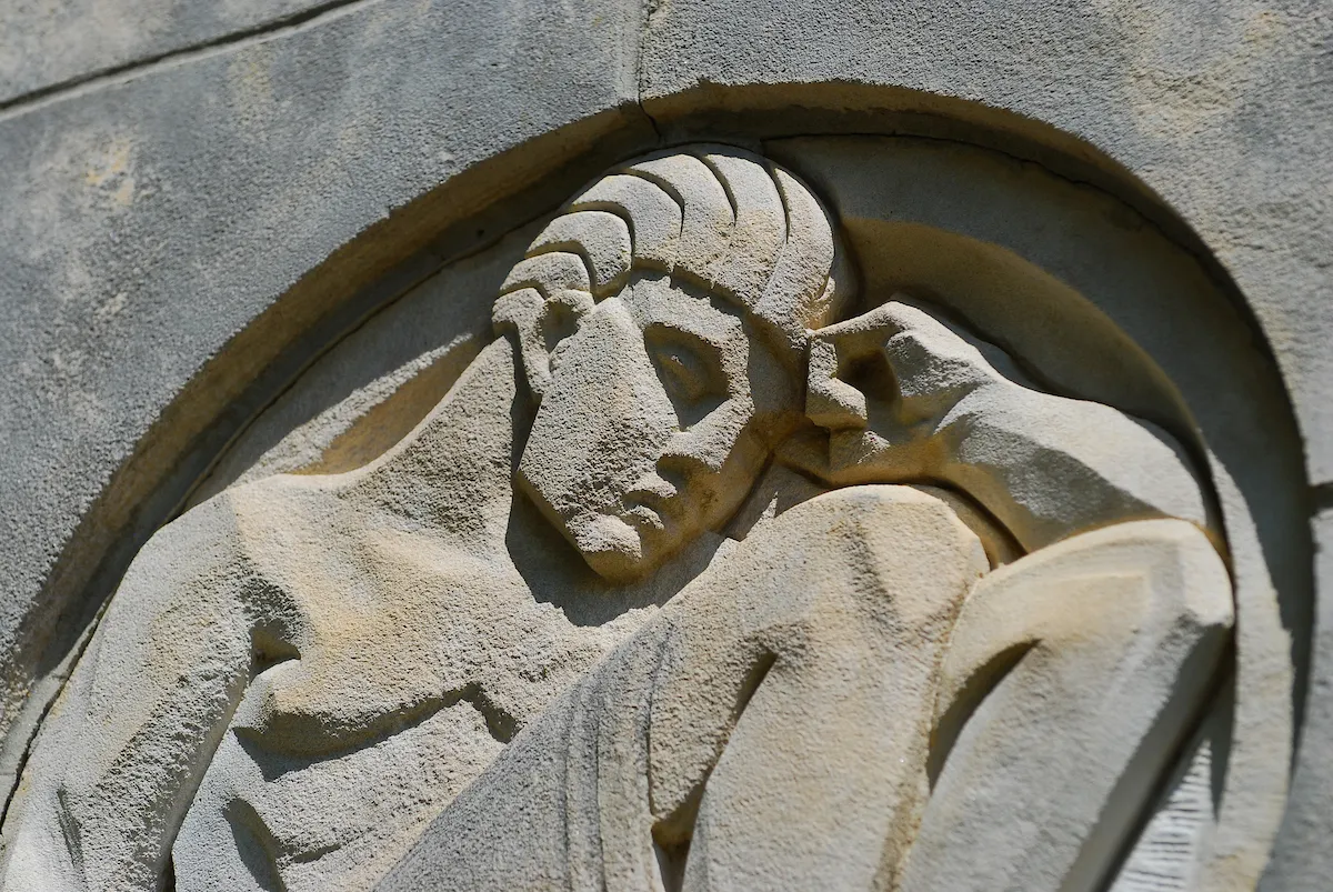 The scholar carvings in the side of Wilson Hall