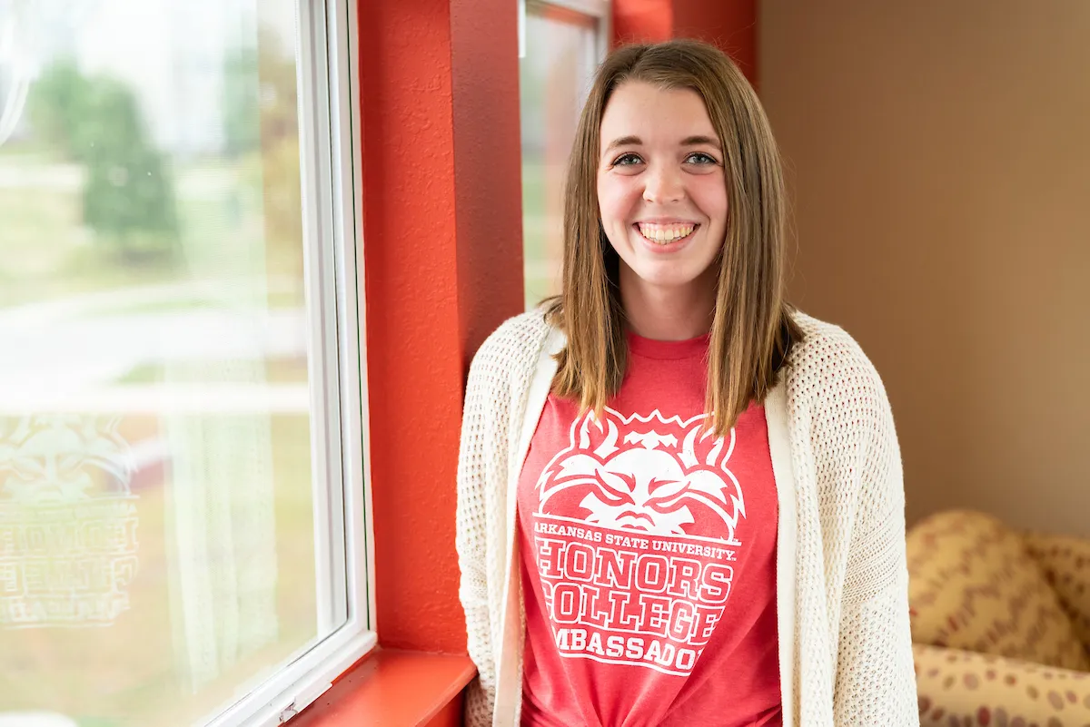 A student wearing an honors ambassador t-shirt