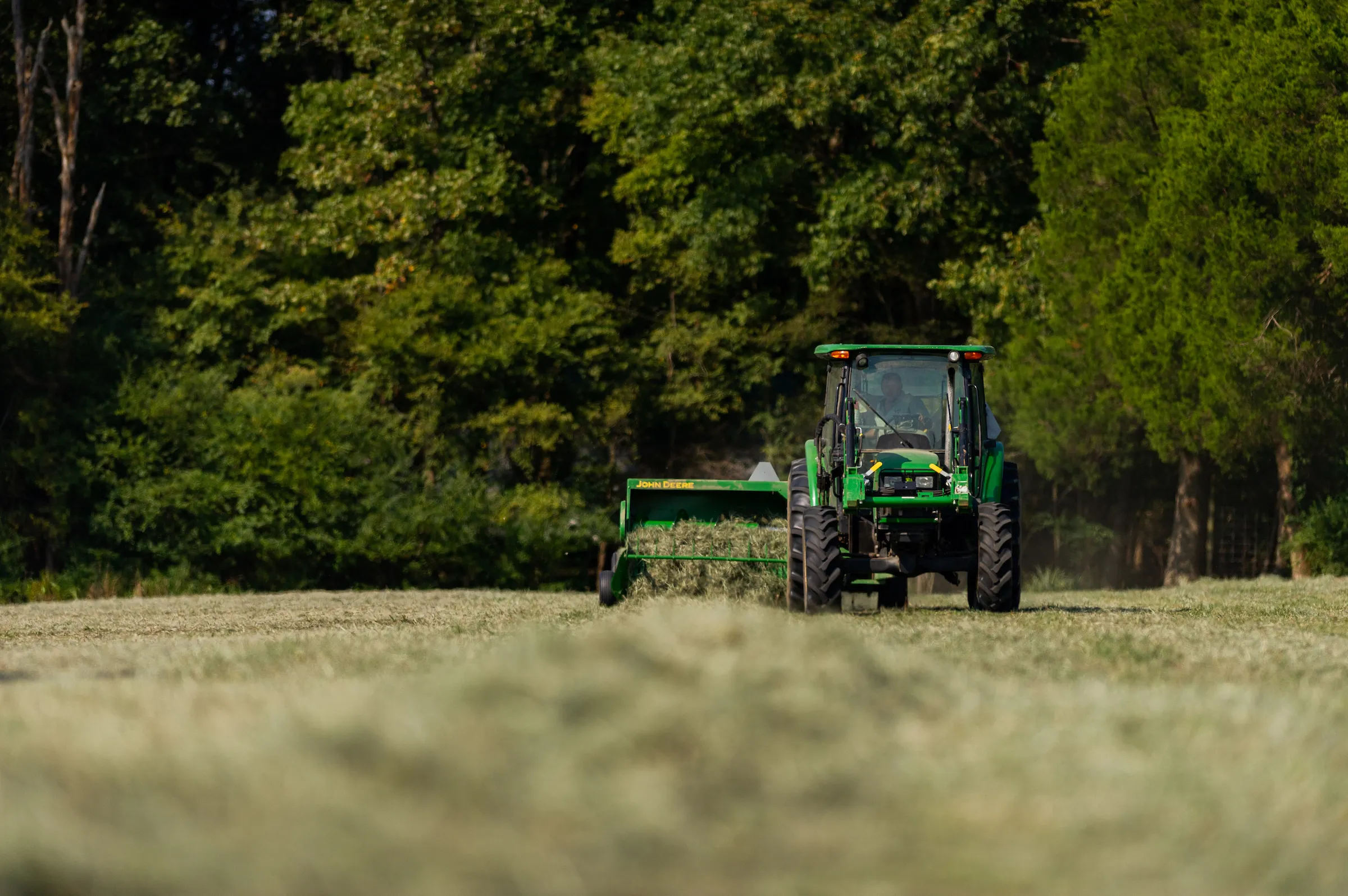 A tractor bails hay on the university farm.