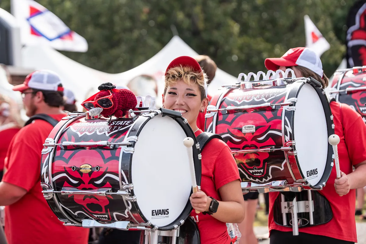 An A-State bass drummer smiles at the camera