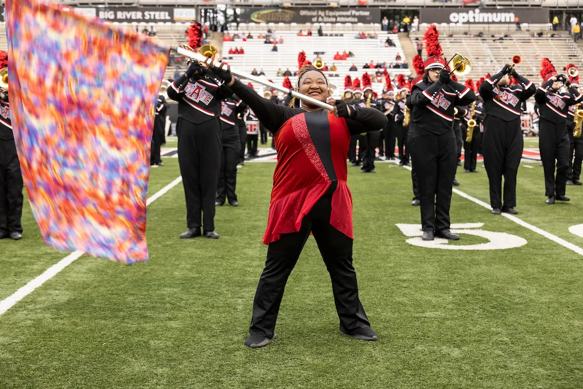A color guard member performs on the field
