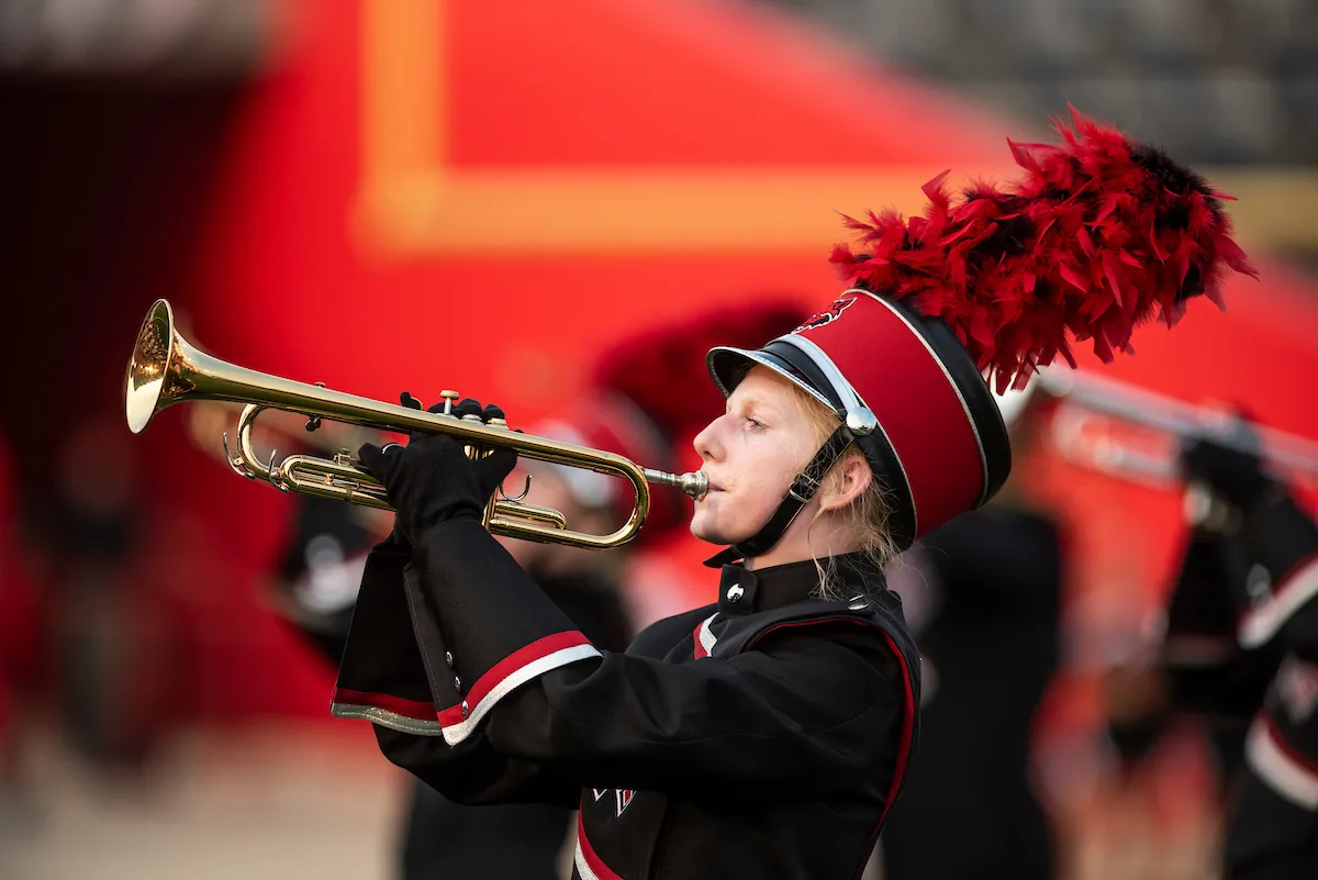 A trumpet player performs on the field