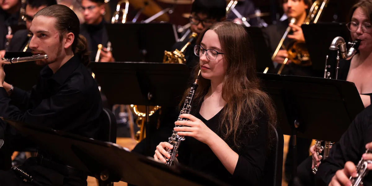 A-State concert ensemble clarinet player performs on stage alongside fellow musicians during a live orchestral concert.