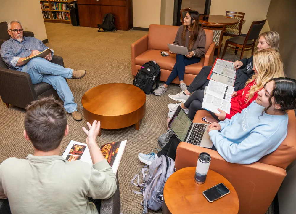 Dr. Lewis teaching in the banking lounge to students on couches