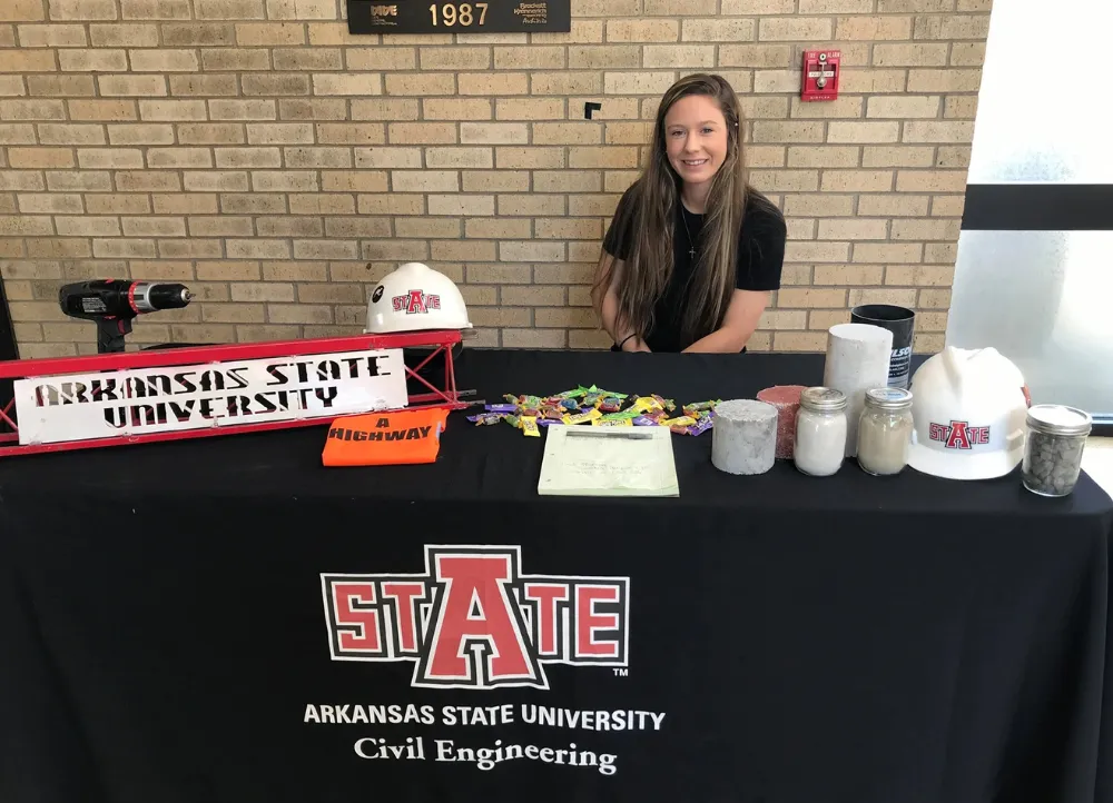 Paige sitting at a civil engineering booth at a campus event