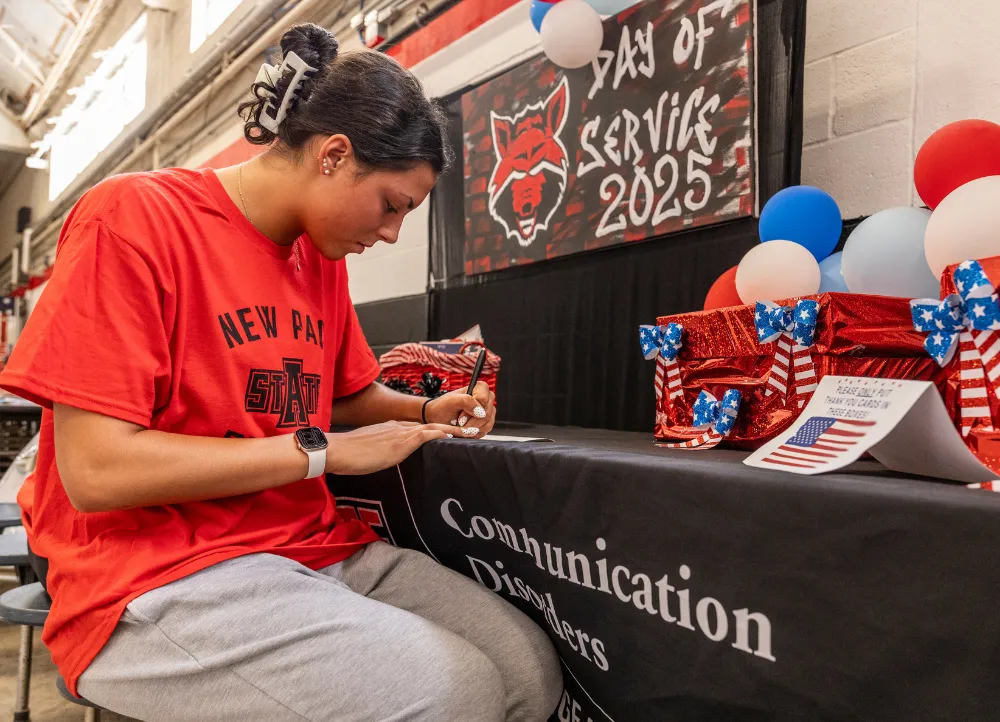 Student at communications disorders booth for the 2025 day of service event.