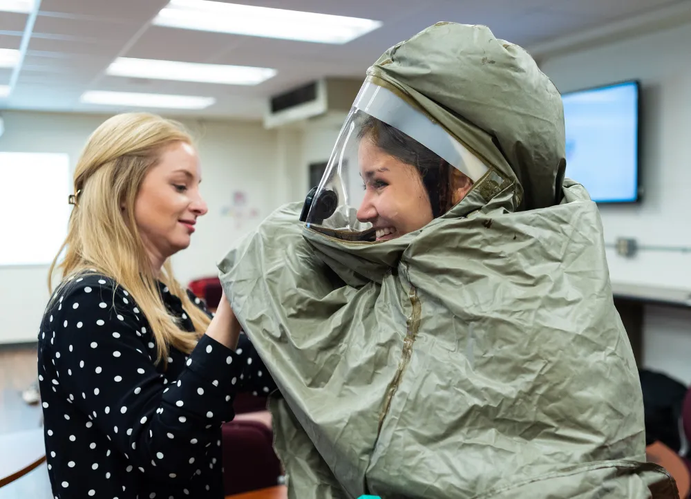 Disaster Preparedness students putting on hazmat suits and laughing.