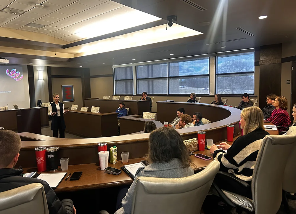 A Leadership in Banking seminar, where attendees are gathered around to listen to a presentation.
