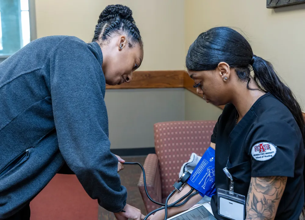 Students in nursing doing each others vitals