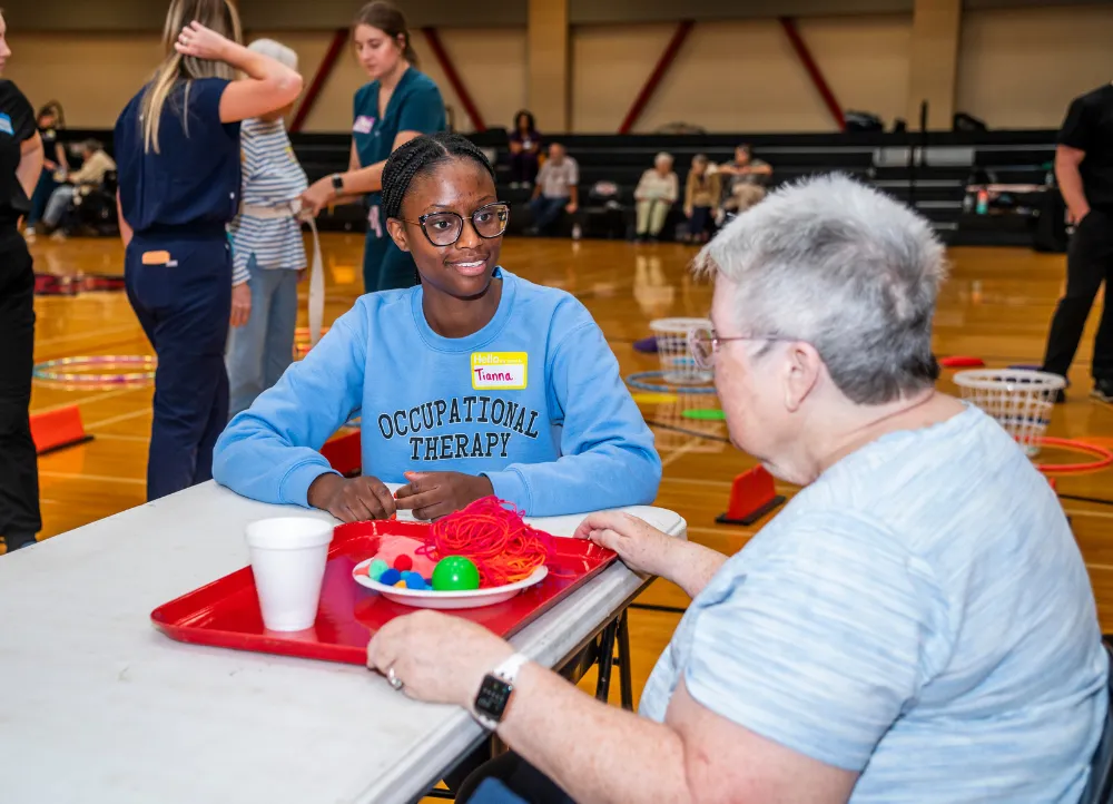 Occupational Therapy student working with senior at the parkinson's bootcamp