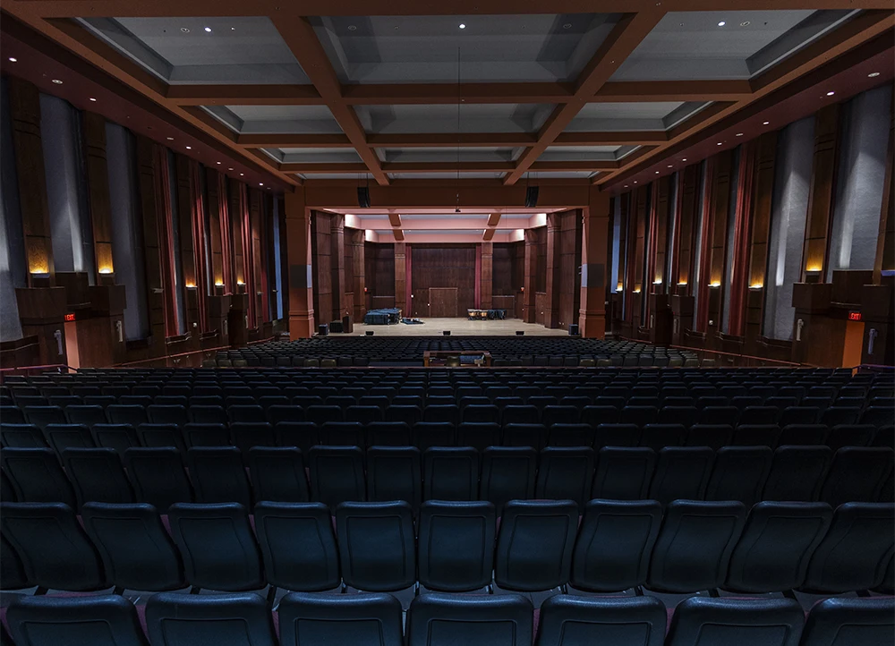 A view of the Riceland Hall stage from the back row of audience seats.