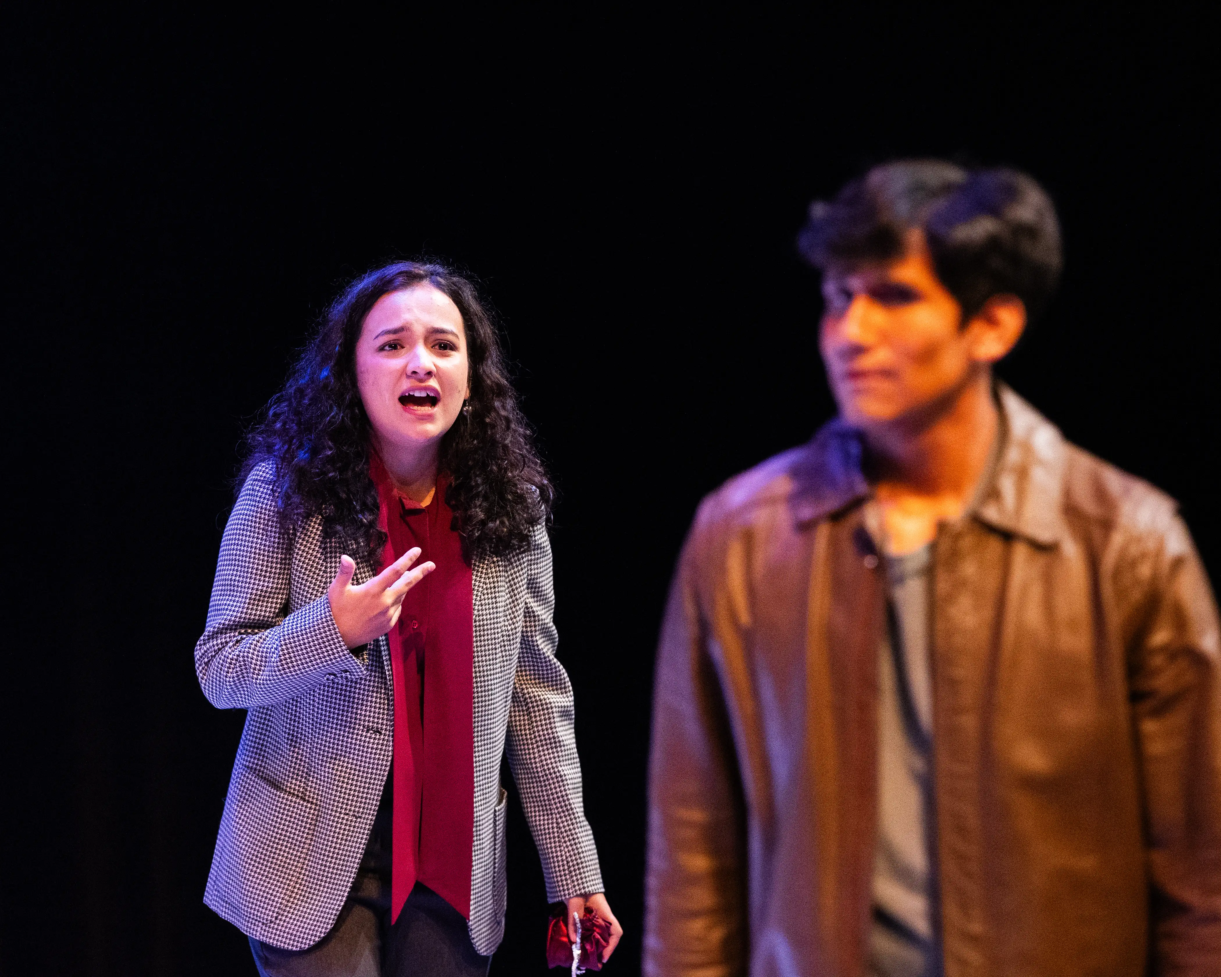 An actress singing to someone in the foreground.