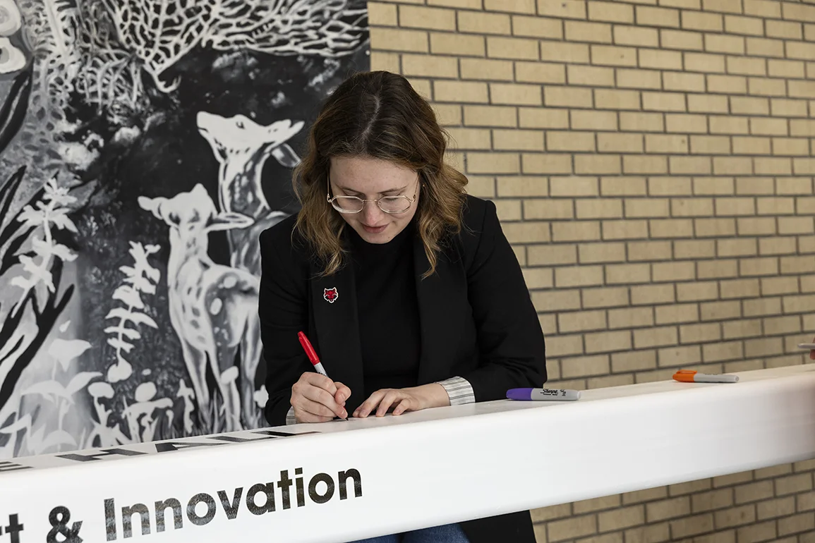 A pillar for the Windgate Hall of Art & Innovation being signed.