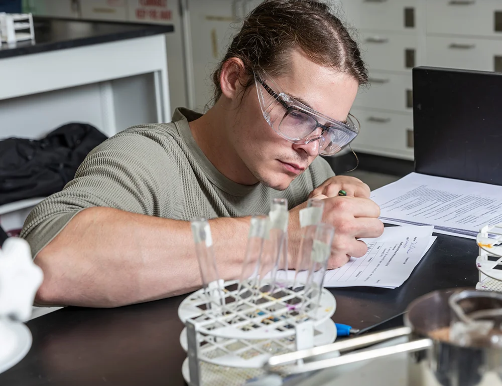 Student taking notes on an experiment.