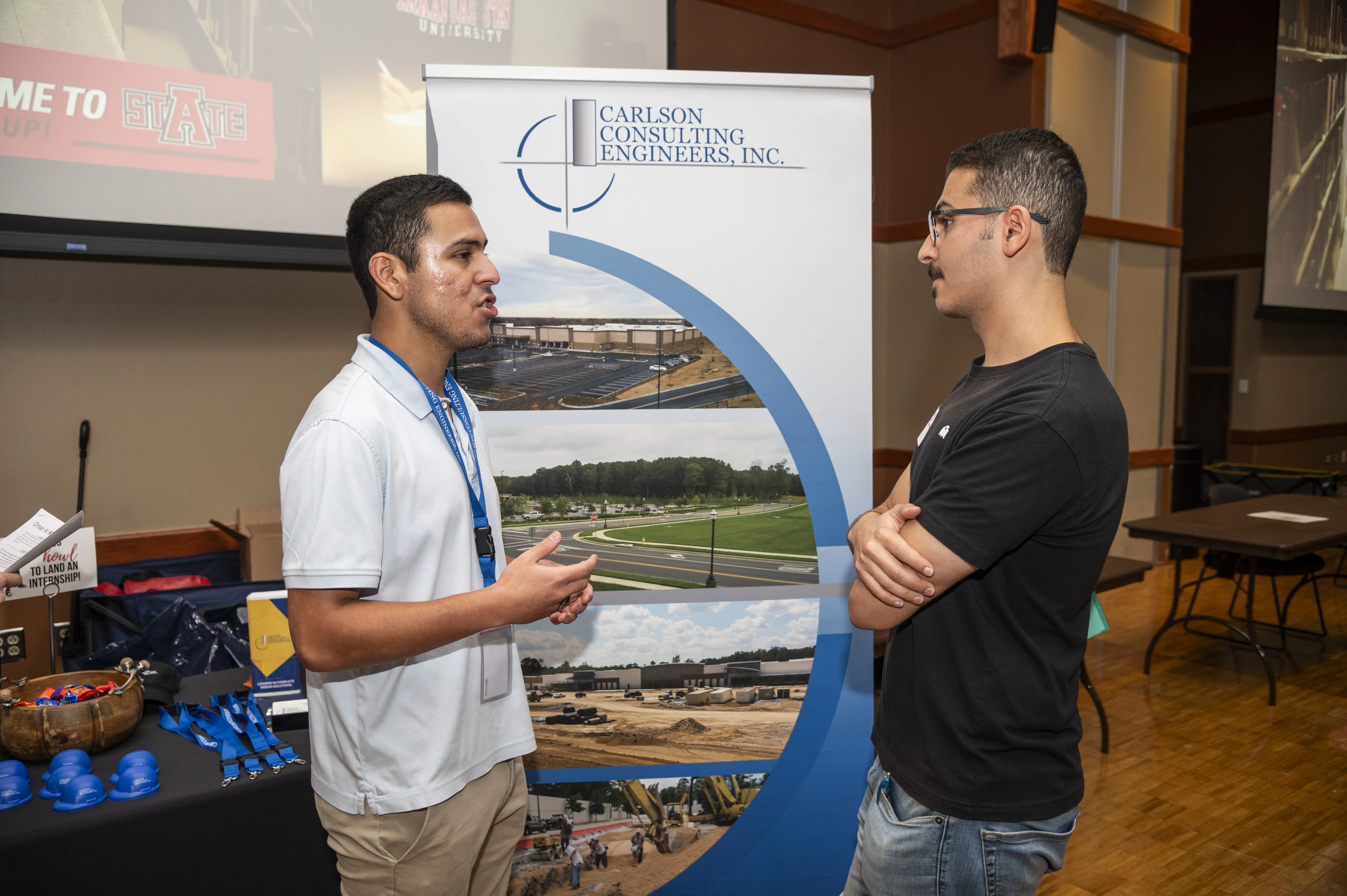 A-State job fair with engineering student talking to an engineering company