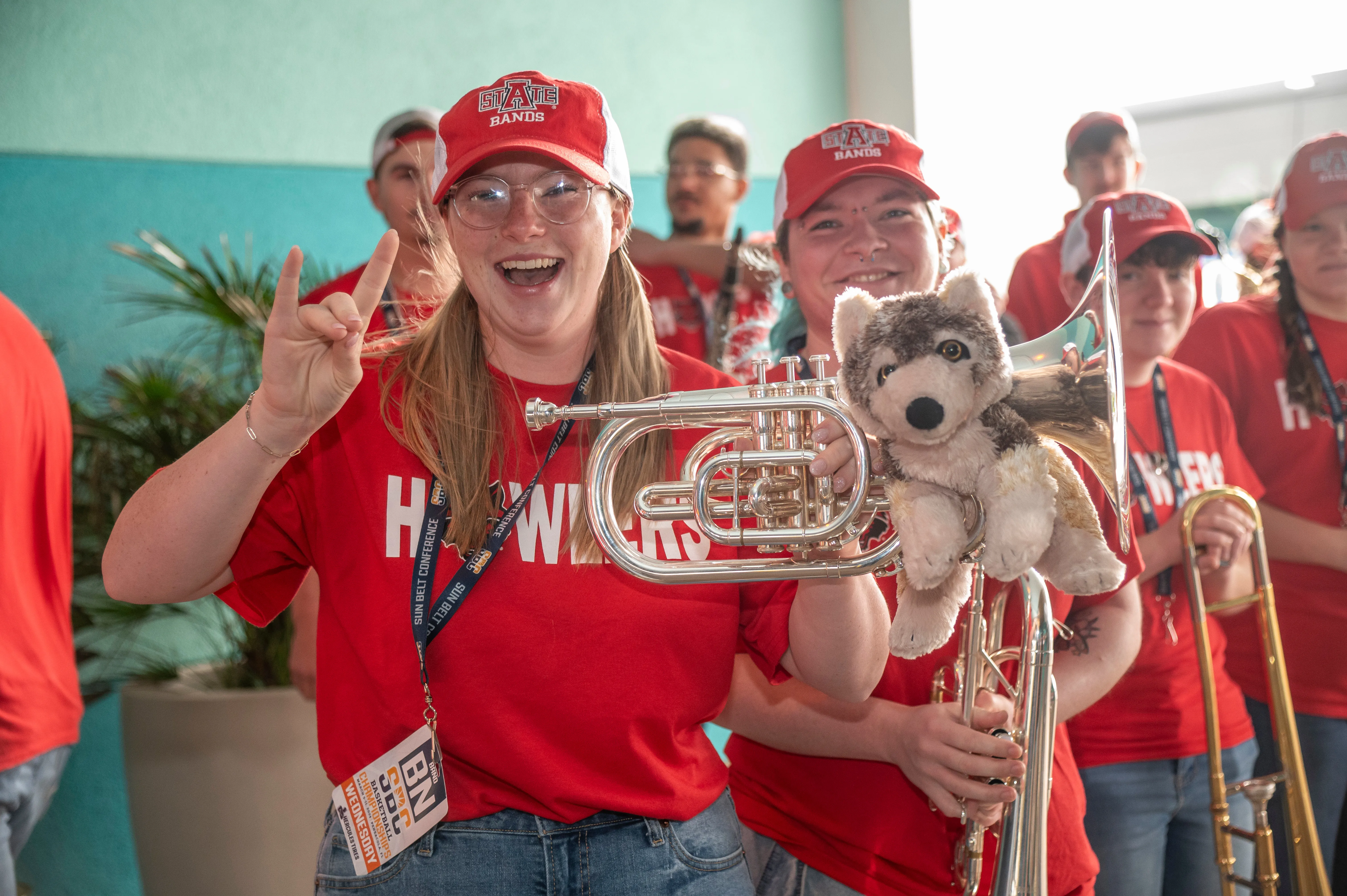 The Howlers band giving a Wolves Up with their instruments in hand.