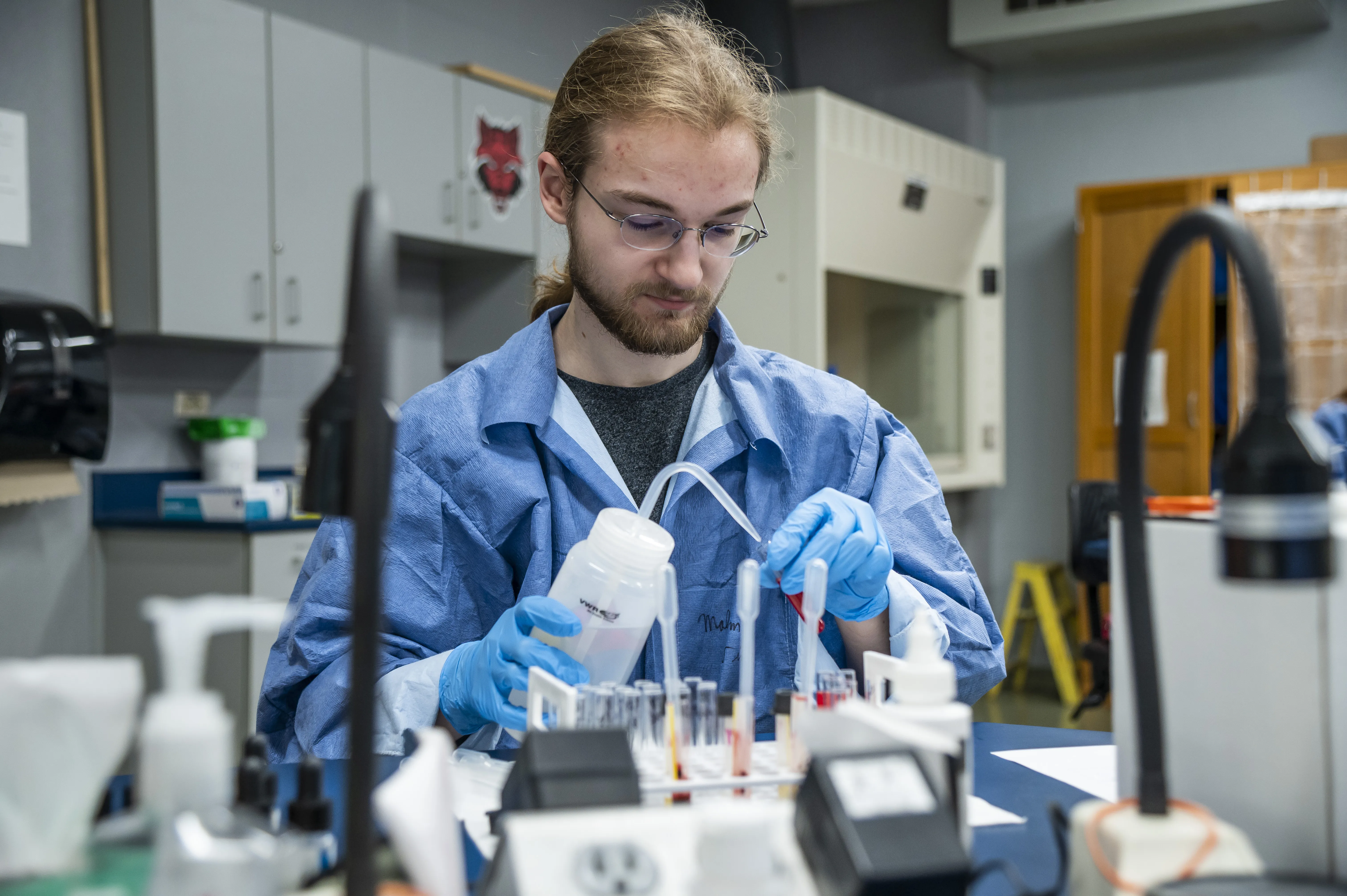 A student filling test tubes.