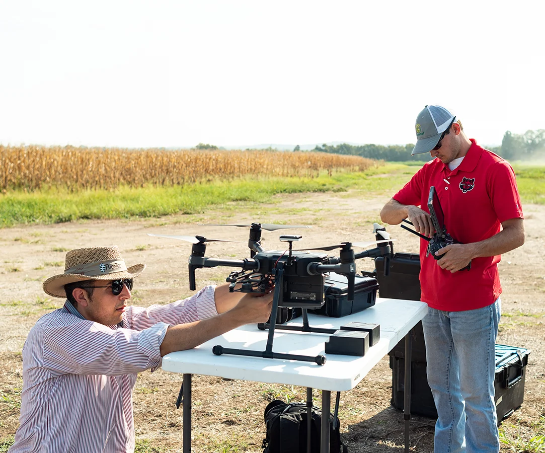 Students working on drones in a field.