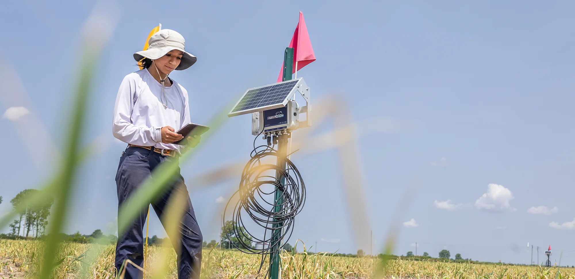 A student using a solar powered device in a field.
