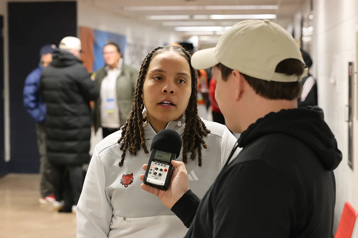 A journalism student interviewing a coach.
