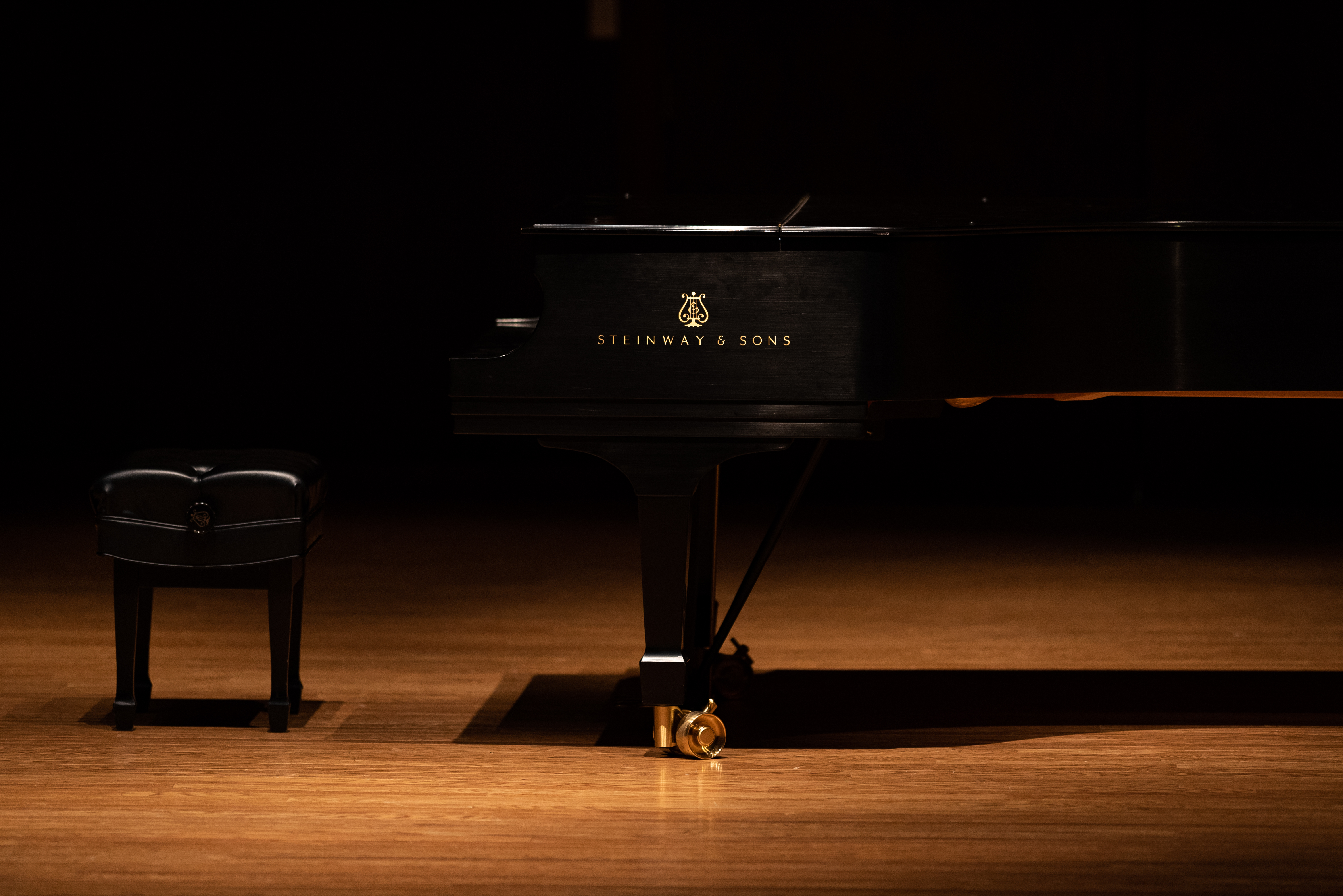 A photo of a piano dimly lit by a spotlight.