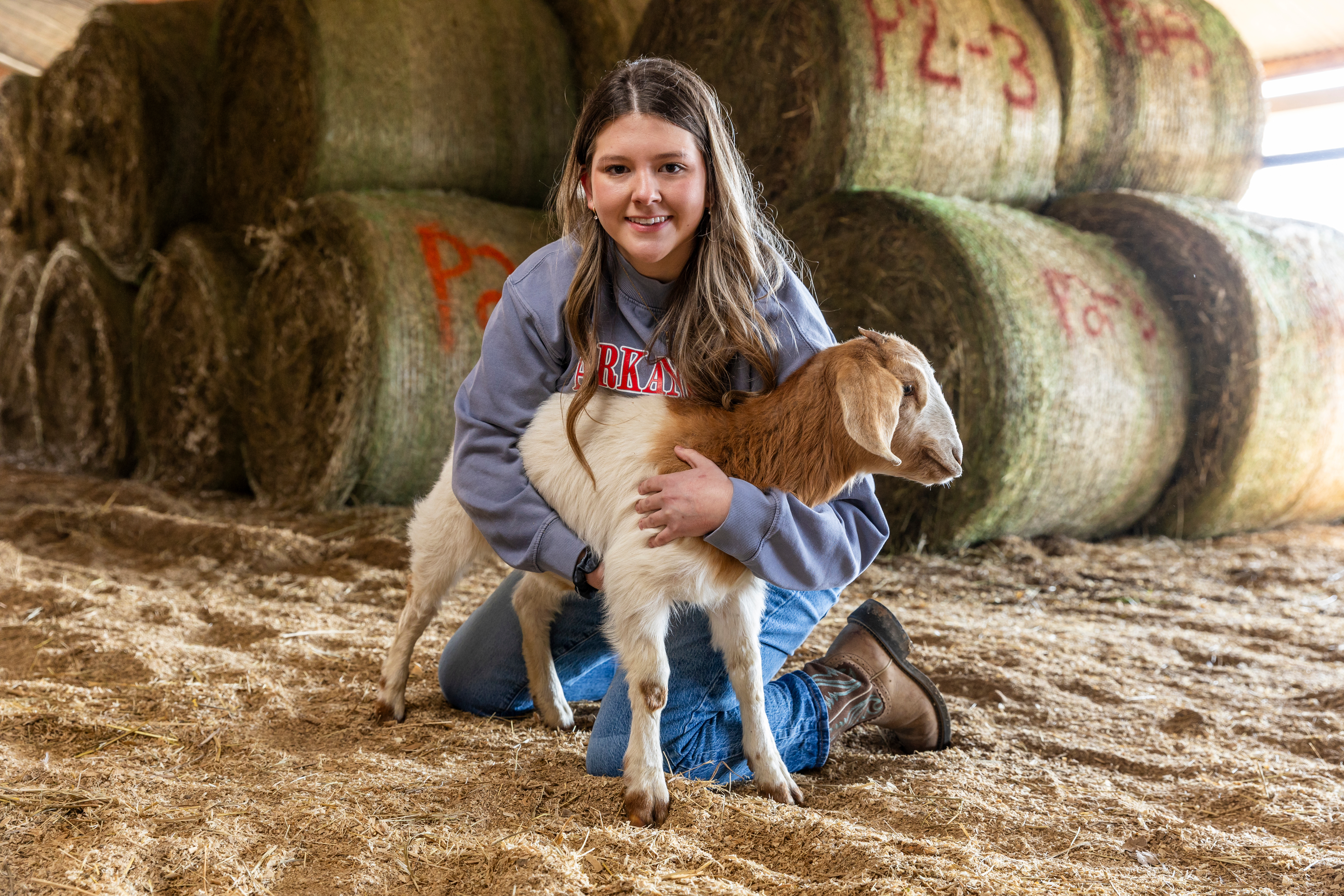 A student holding a baby goat.