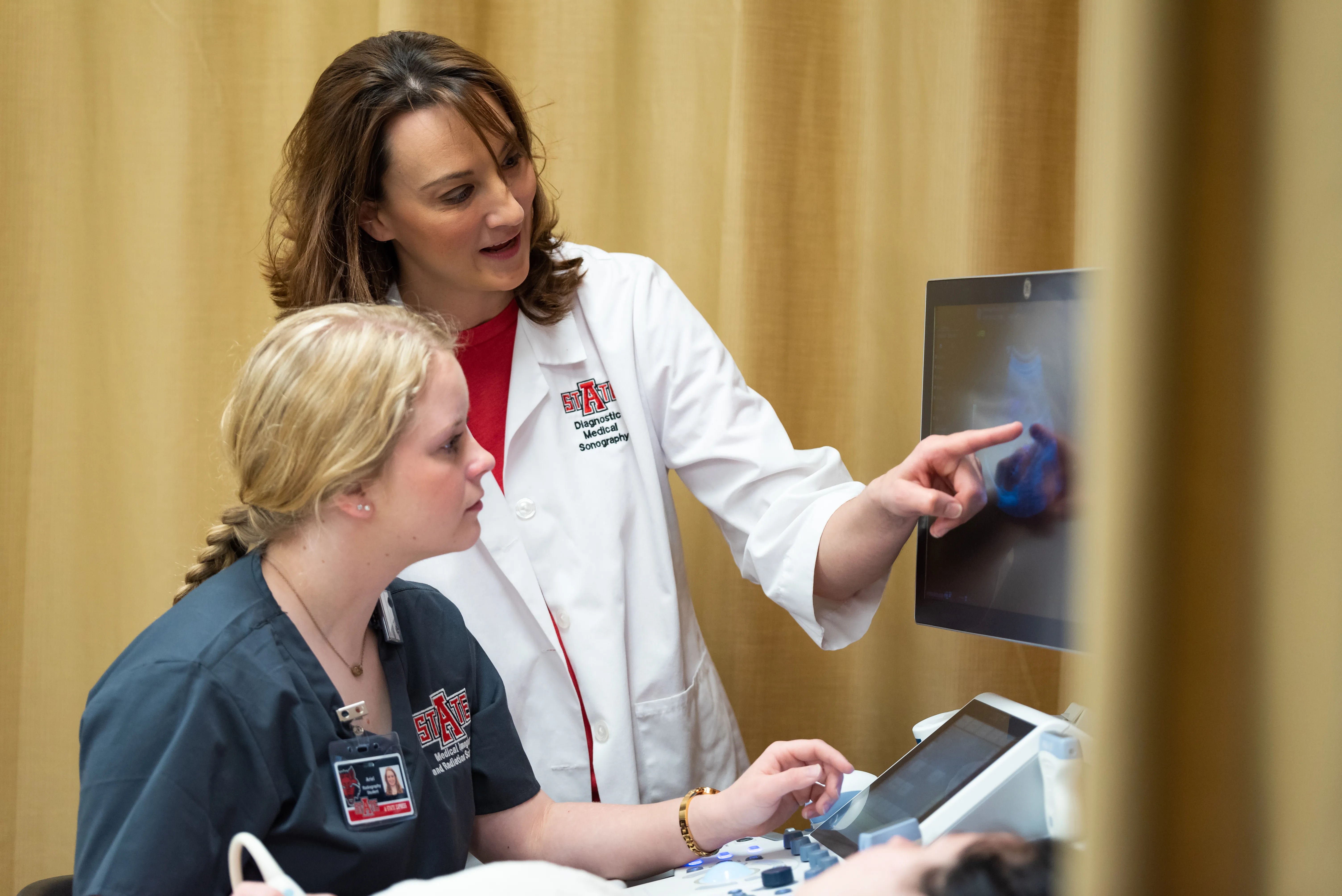 A-State radiology professor showing a student how to read an image.