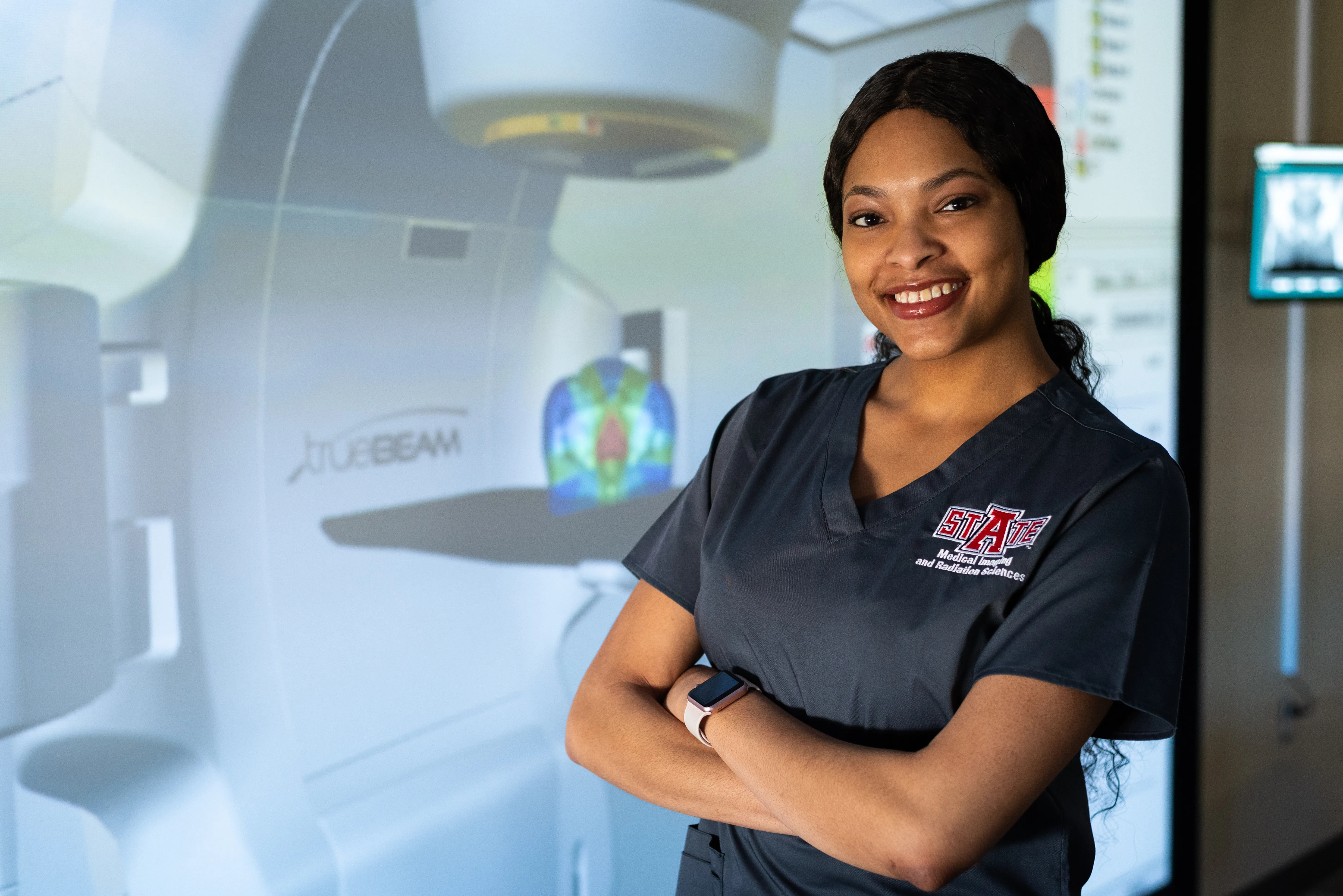 A-State radiology student next to large vr mri machine
