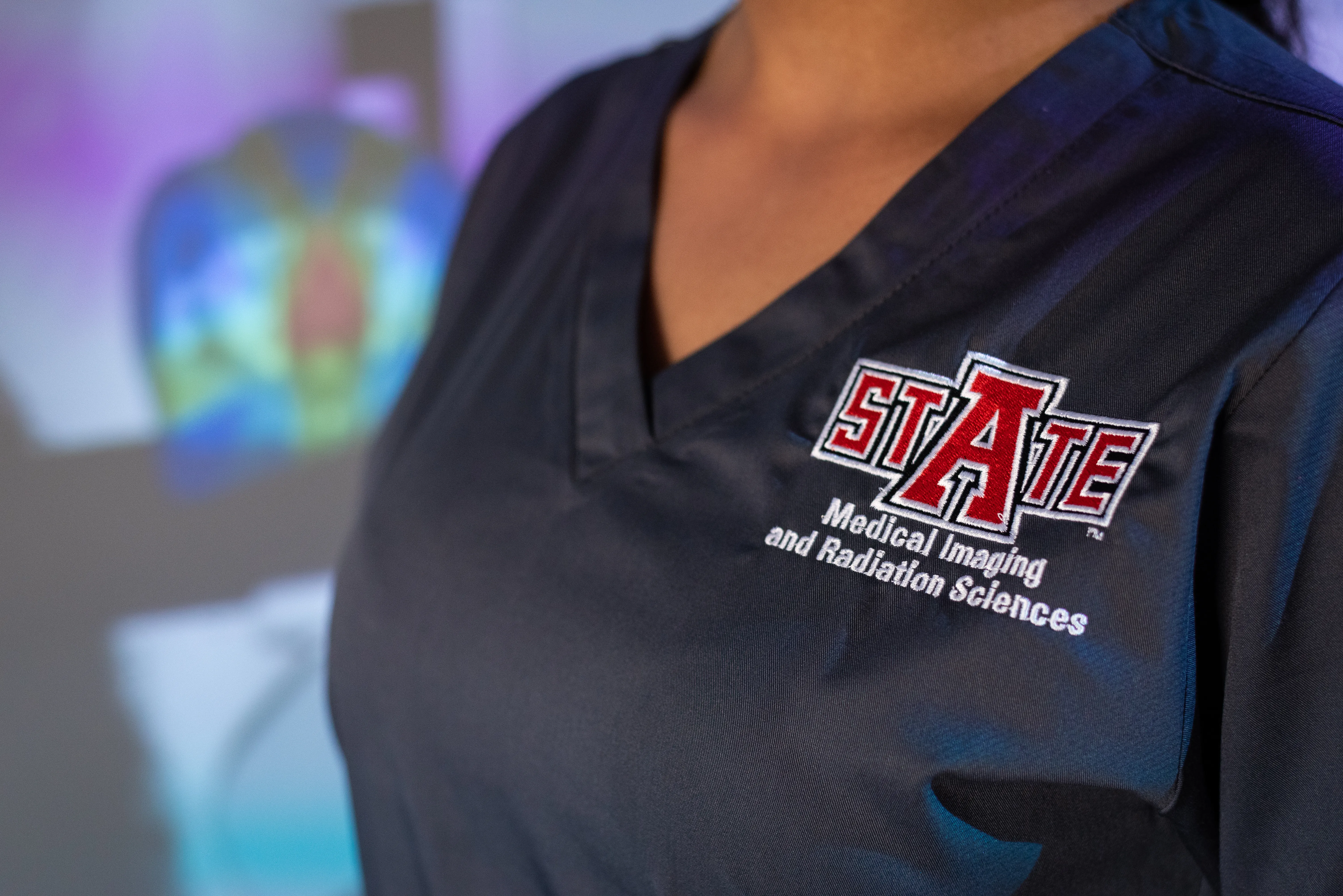 Radiation Therapy student with branded scrubs on.