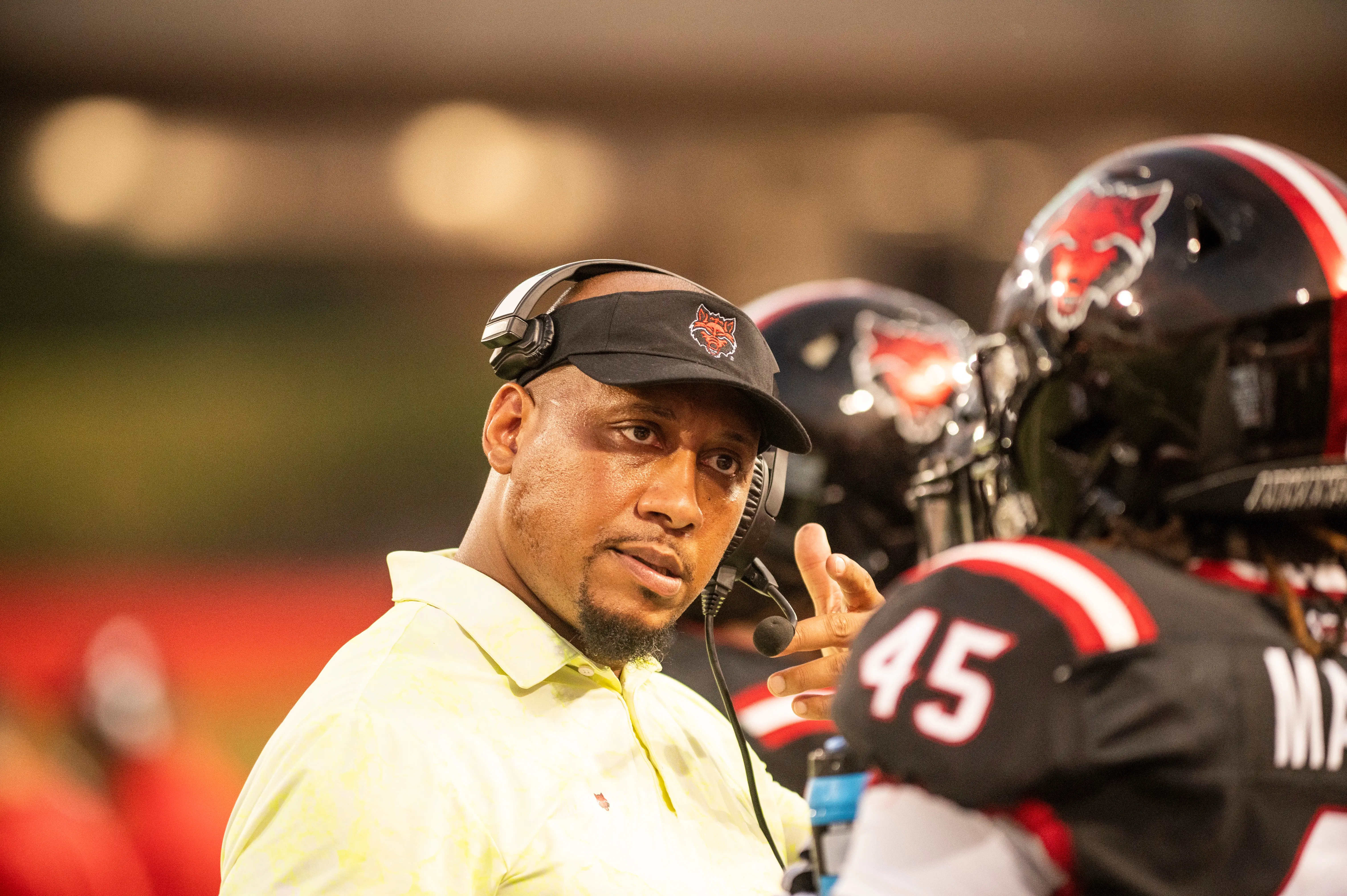 A coach talking to a football player.