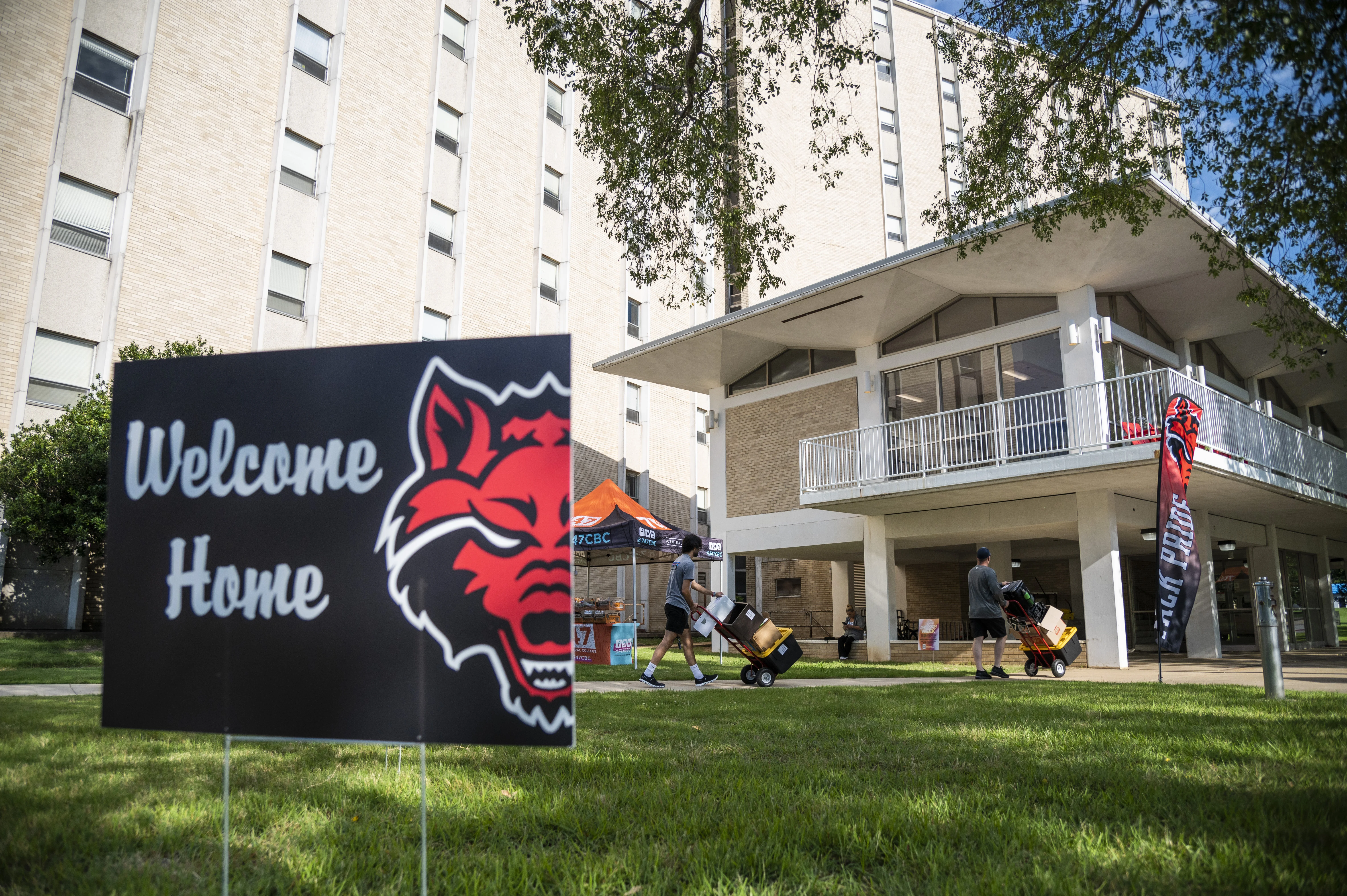 Welcome Home sign in front of residence hall as people are moving in.