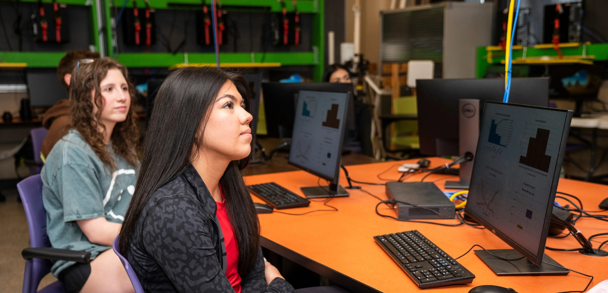 A-State students going over data science graphs on computers in an AI class.