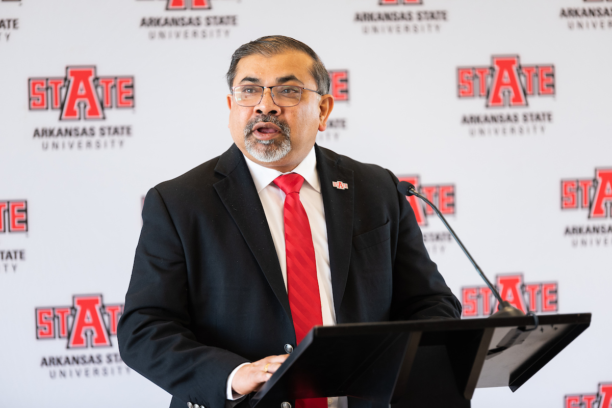 Abhijit Bhattacharyya addresses a crowd from a podium.