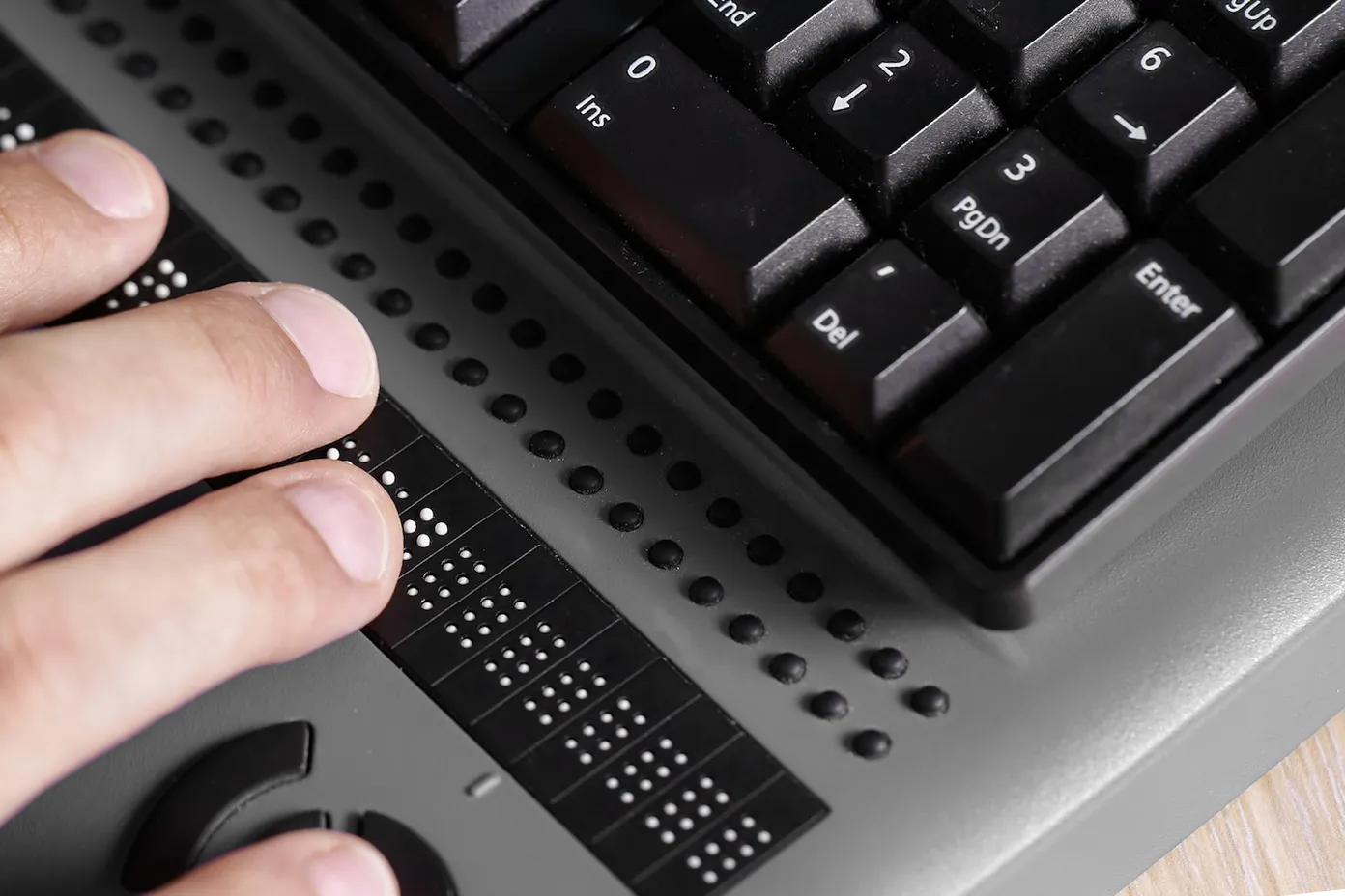 hands typing on a braille keyboard