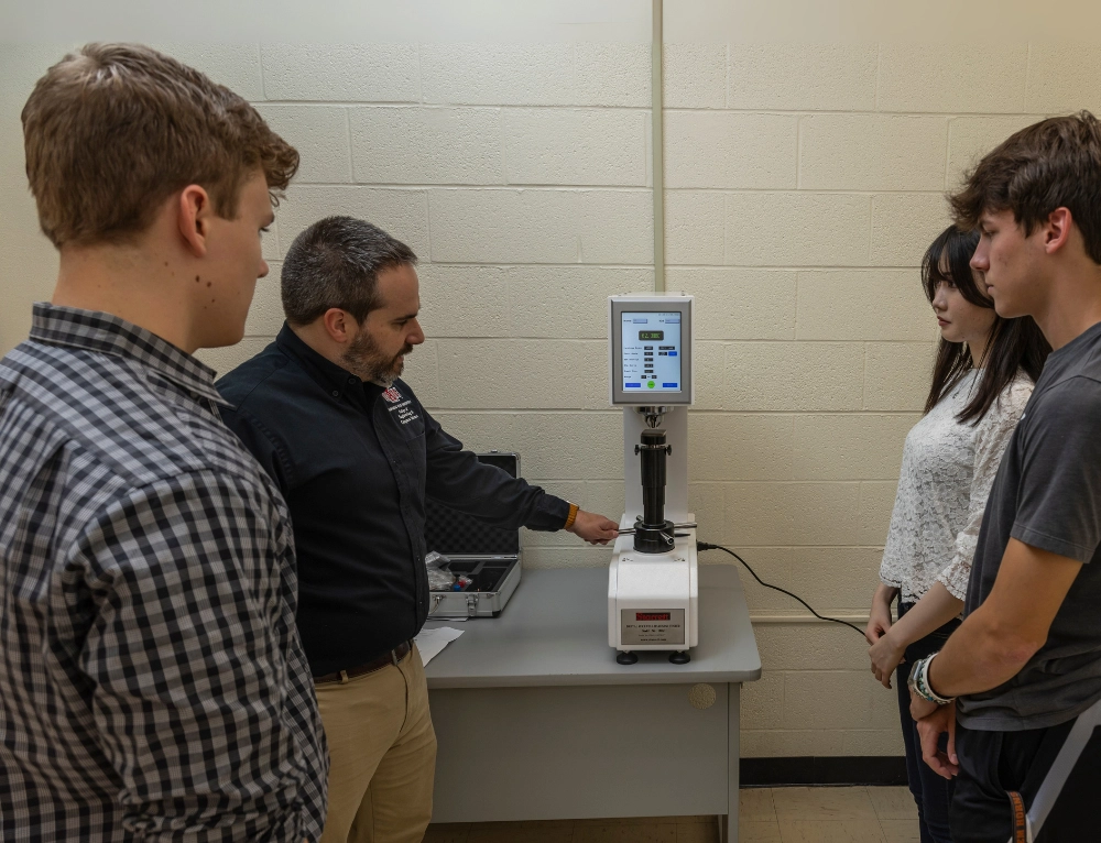 Advanced Materials class with instructor going over equipment with three students.