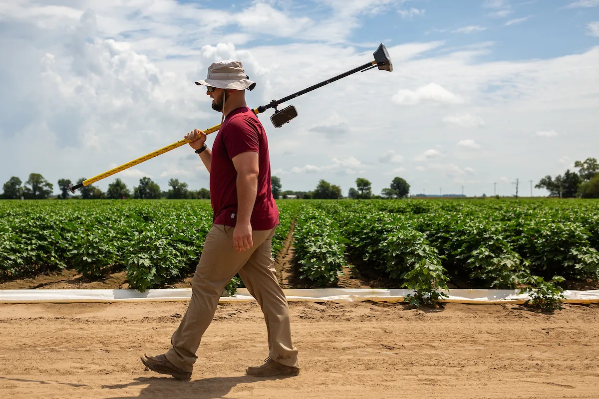 A student works to take GPS measurements in a campus crop field