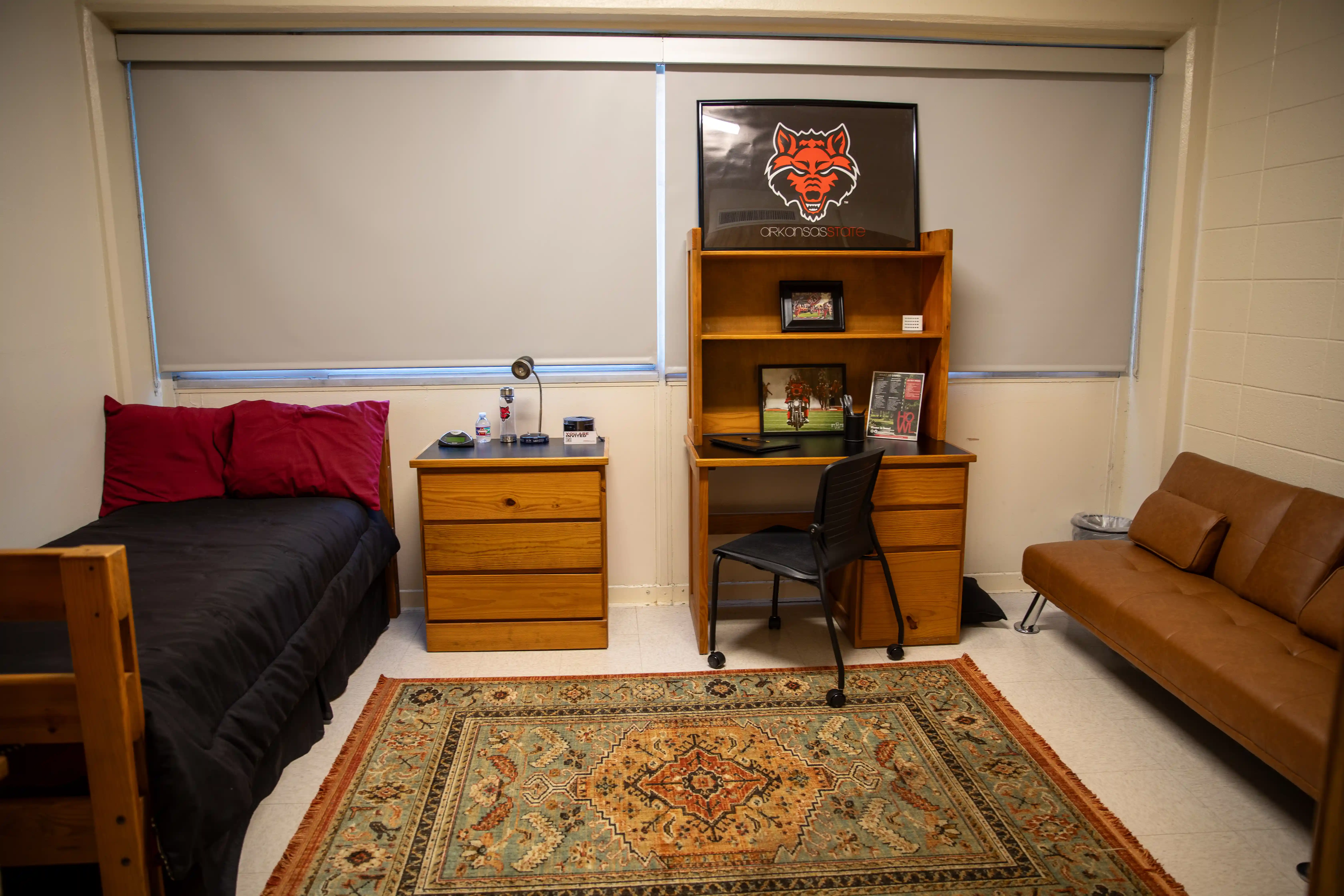 Arkansas Hall Bedroom with twin-size bed, desk, rolling chair, and chest of drawers.