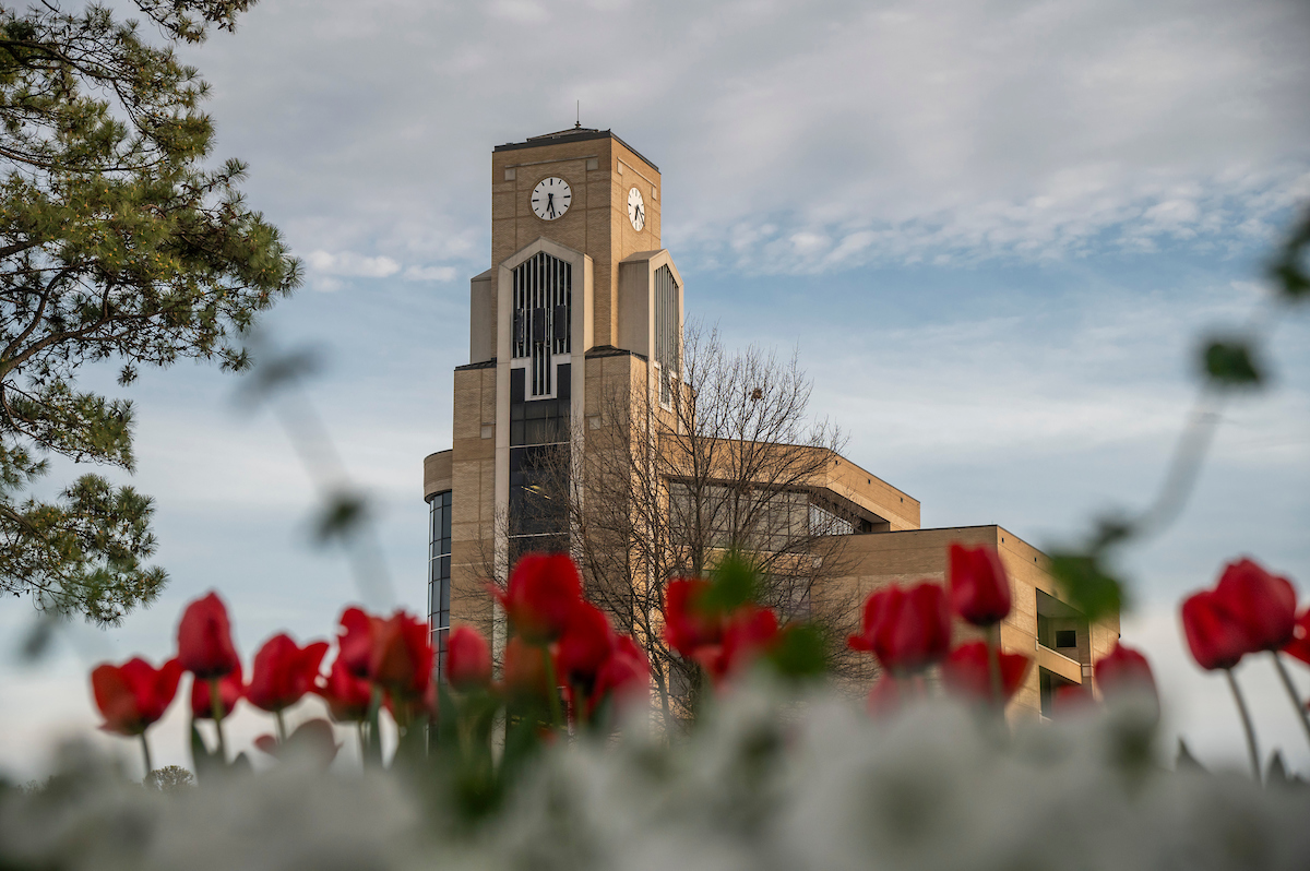 The Dean B. Ellis Library surrounded by red flowers.