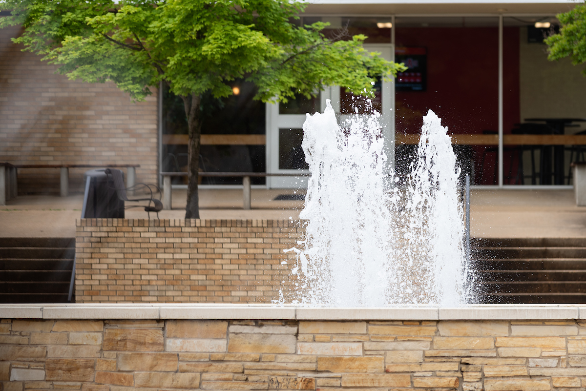 Fountain on campus surrounded by trees.