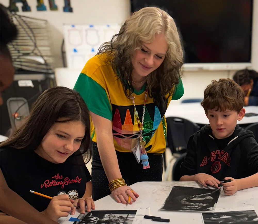 Alumni Jessie Martin with her art students, working on a project.