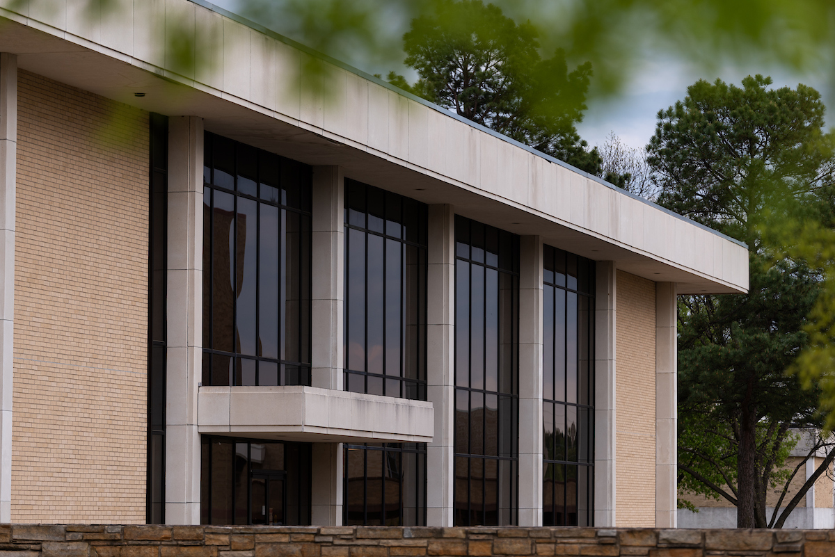 Exterior of A-State Administration building with modern glass and column design.
