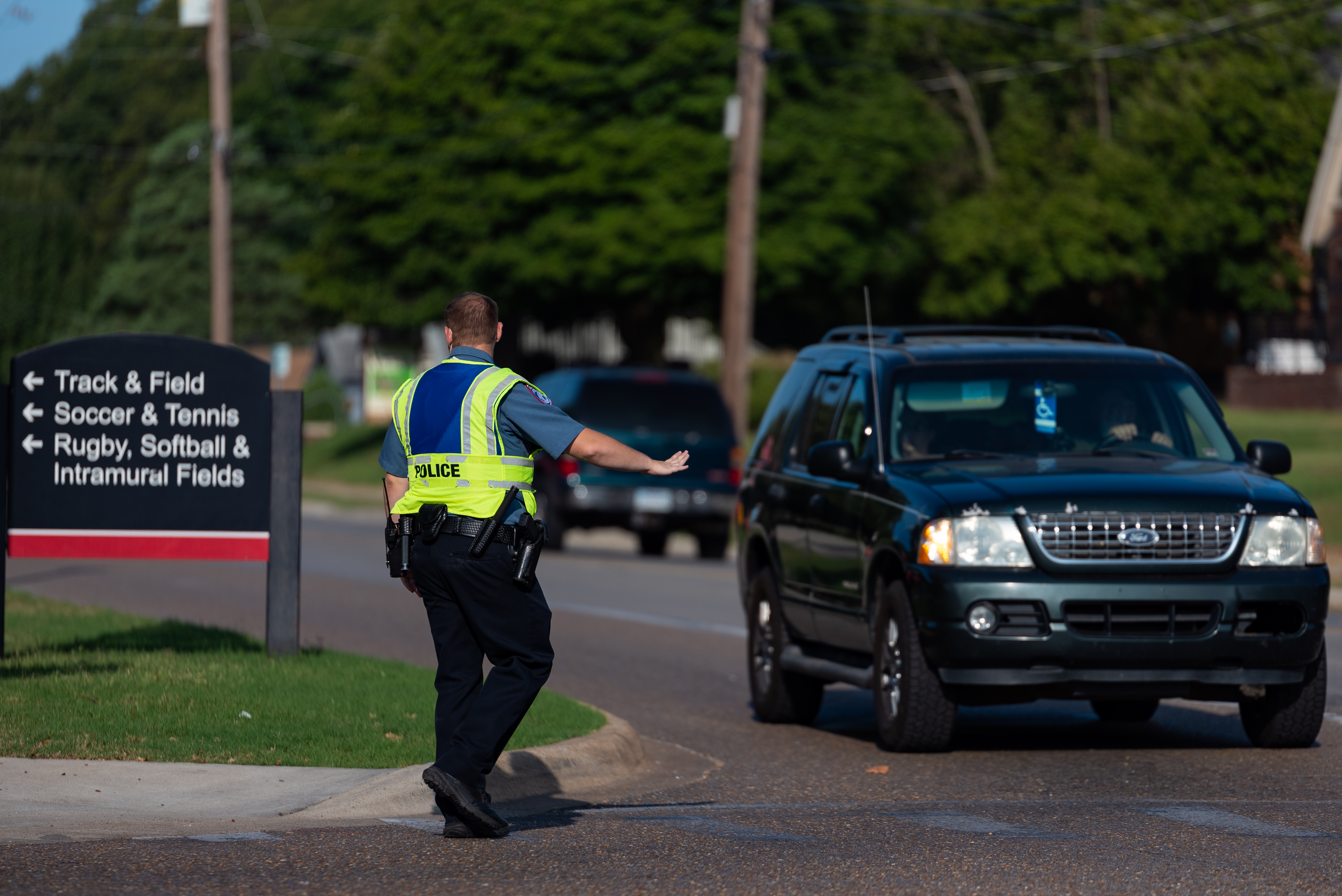 A campus police officer directs traffic on campus