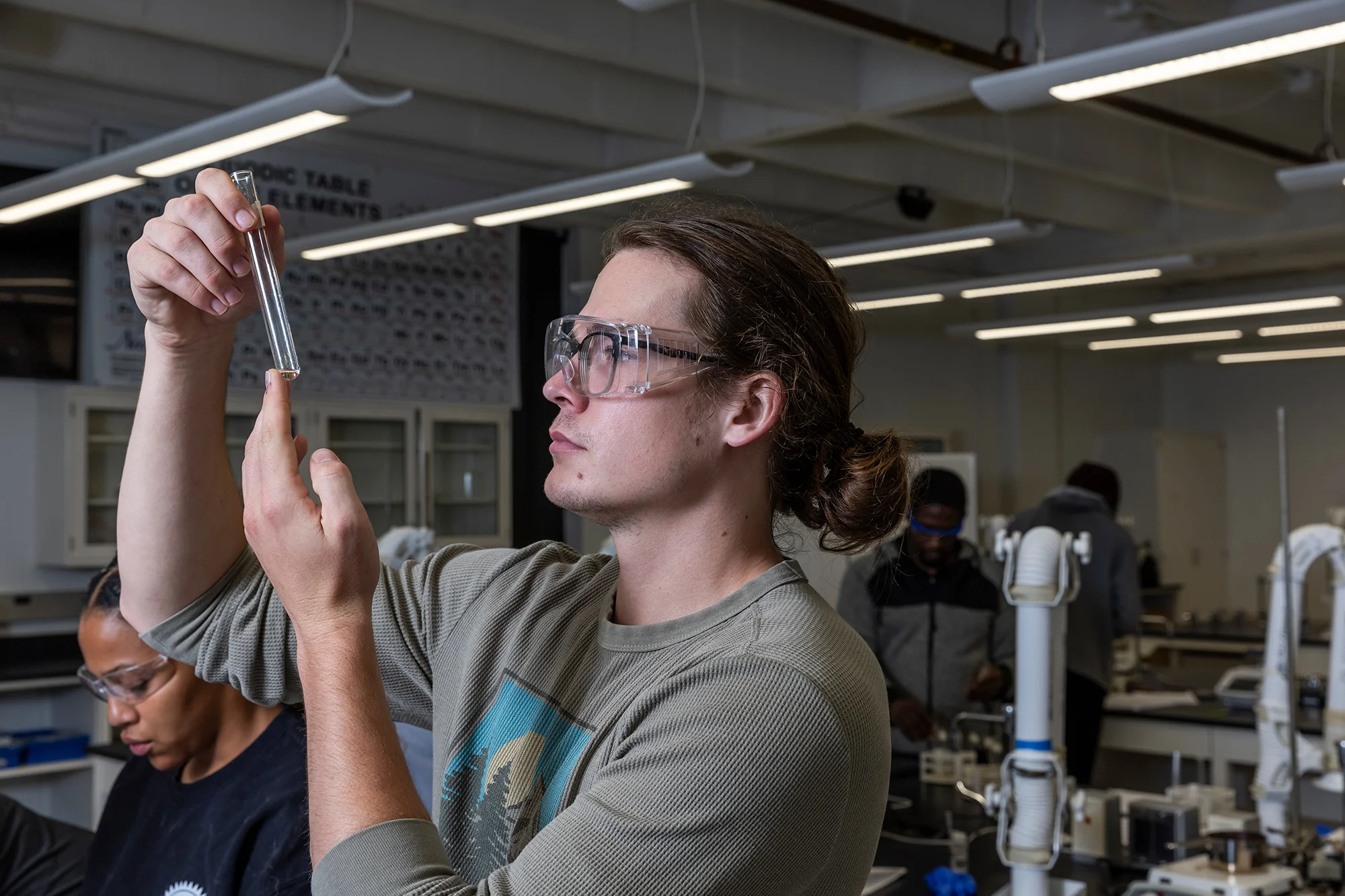 A student holding up a vial to inspect it.