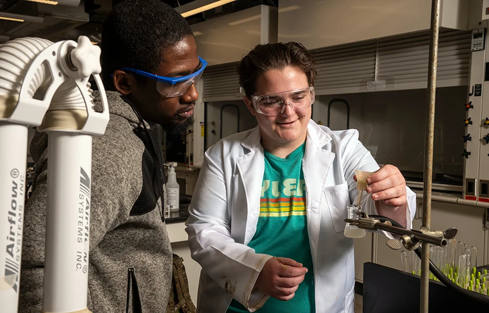 Chemistry professor helping student with experiment.