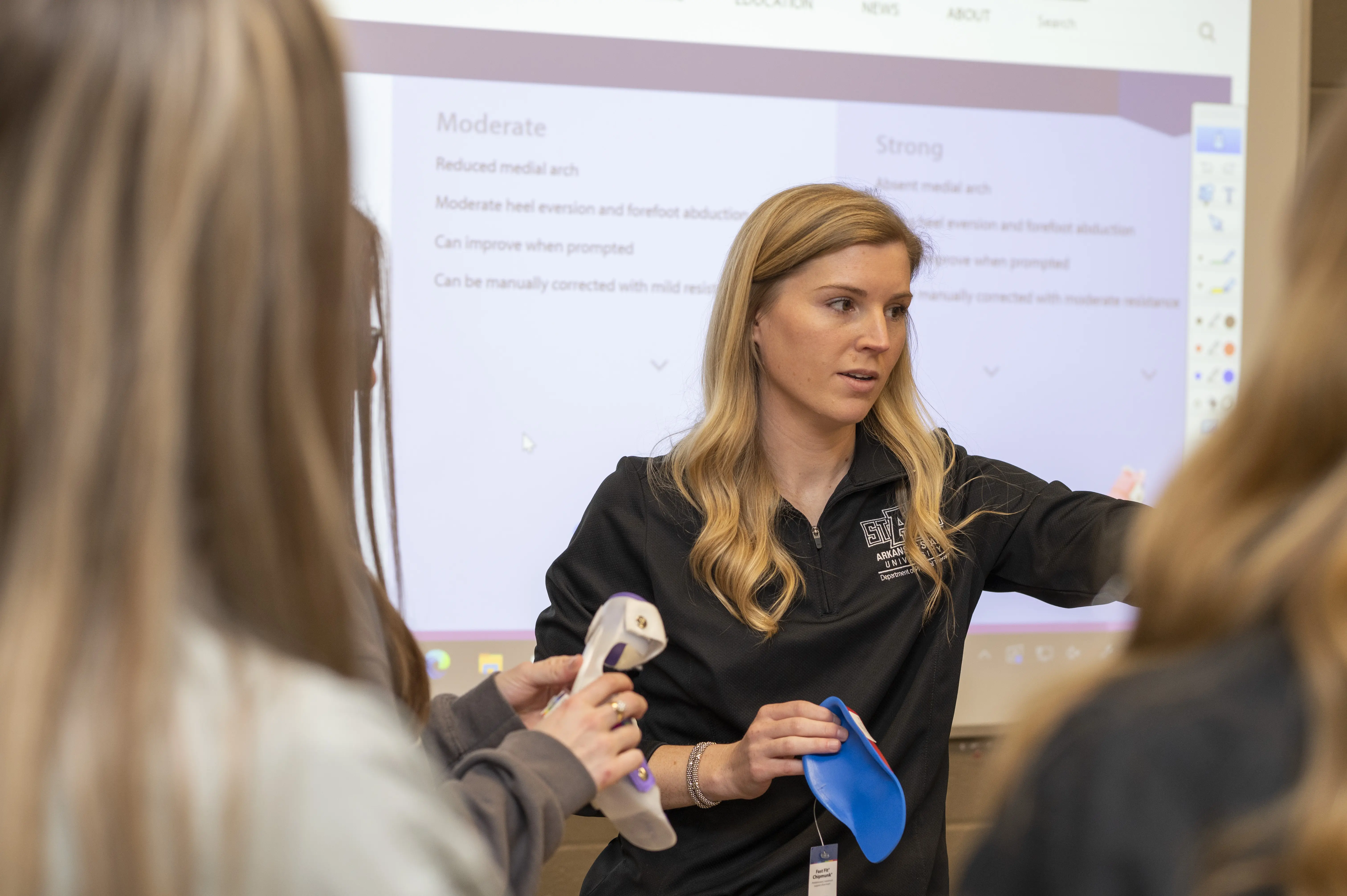 A-State student on doing physical therapy in red wolves shirt.