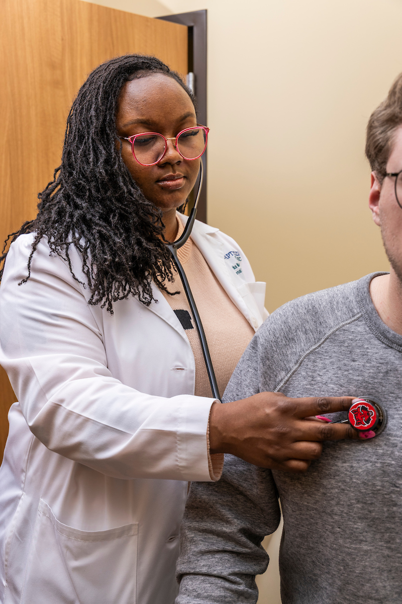 A student being checked with a stethoscope.
