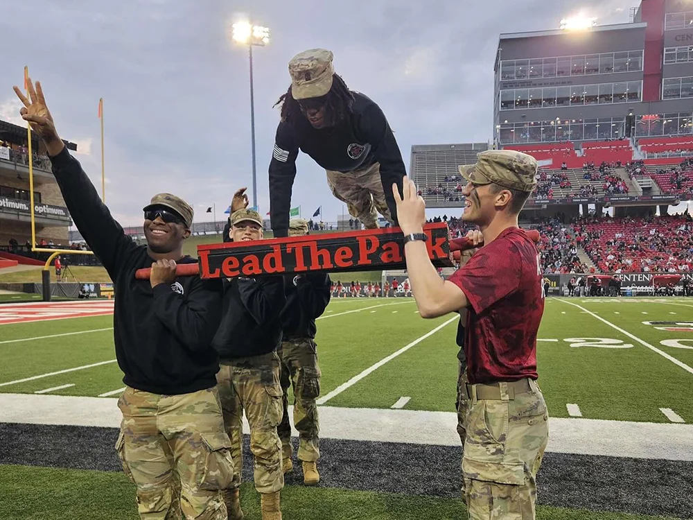 ROTC students doing push-ups on the sidelines of a Red Wolves football game.