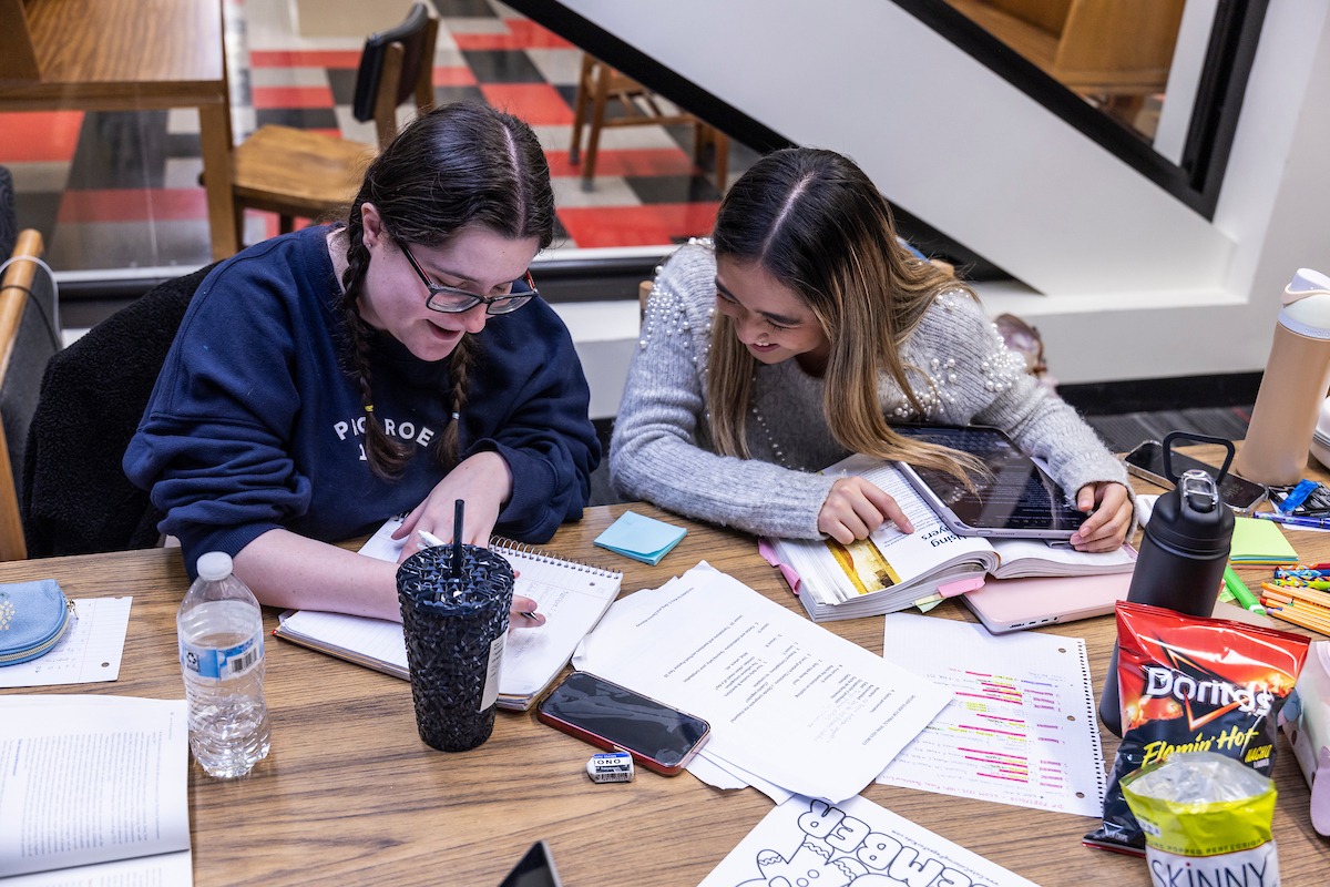 Two students taking notes together.