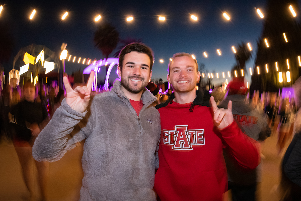 Two students smile during a festive night campus event.