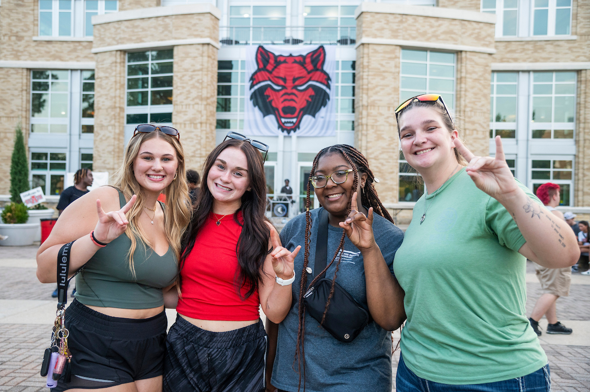 Students hold their 'wolves' up in front of Reng Student Union building.